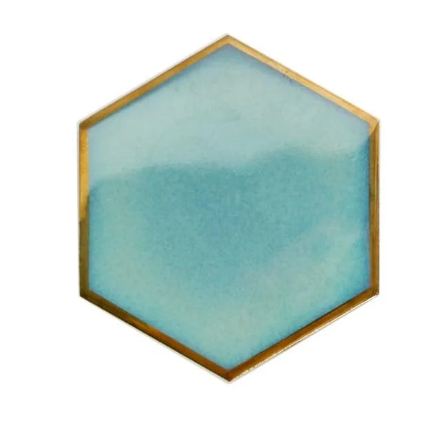 Dessous de verre hexagonal bleu givré clair avec liseré doré, photographié seul sur fond blanc.