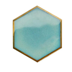 Dessous de verre hexagonal bleu givré clair avec liseré doré, photographié seul sur fond blanc.