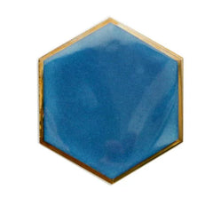 Dessous de verre hexagonal bleu océan avec liseré doré, photographié seul sur fond blanc.