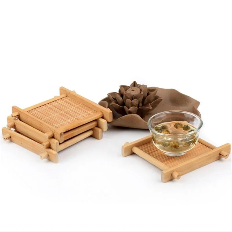 Pile de dessous de verre japonais en bambou à côté d'un bol de thé aux fleurs séchées, sur fond blanc