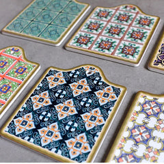 Vue de dessus de plusieurs dessous de verre mosaïque aux motifs différents disposés sur une surface grise.
