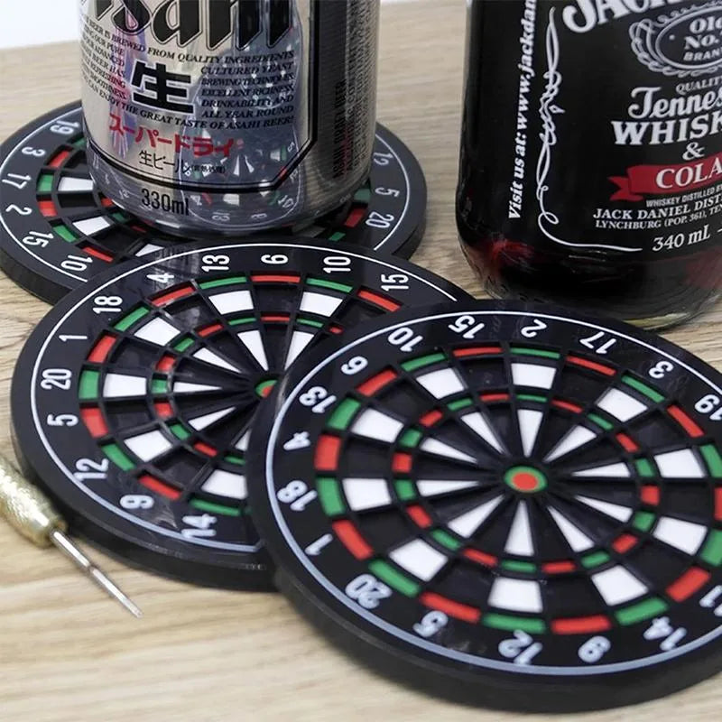 Dessous de verre originaux disposés sur une table en bois avec canettes de bière, bouteille de whisky et fléchette