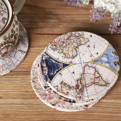 Gros plan sur la pile de dessous de verre vintage posée près d'une tasse à thé à motif floral.