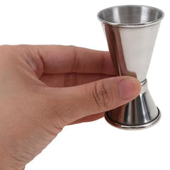 Doseur à alcool cocktail tenu en main pour illustrer sa taille compacte
