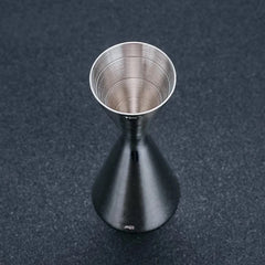 Vue plongeante sur le doseur à cocktail en inox montrant la graduation trente millilitres au fond du cône