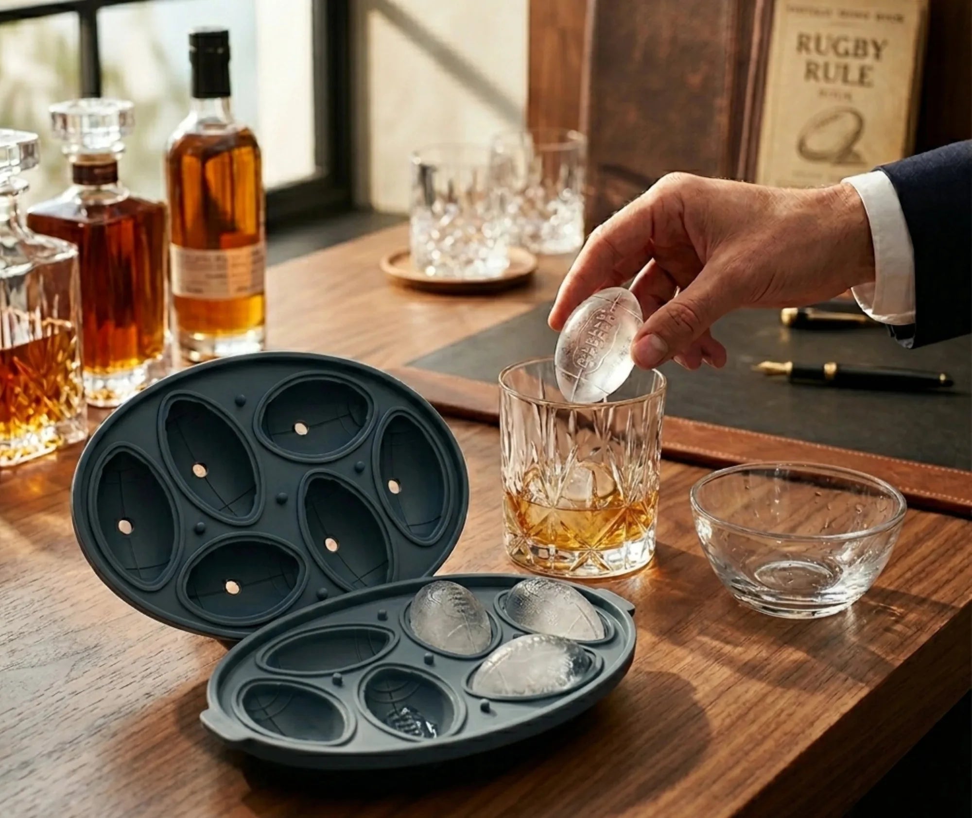 Glaçon en forme de ballon de rugby déposé dans un verre de whisky sur un bureau élégant
