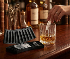 Glaçon en forme de balle de fusil déposé dans un verre de whisky, ambiance bar avec bouteilles en arrière-plan