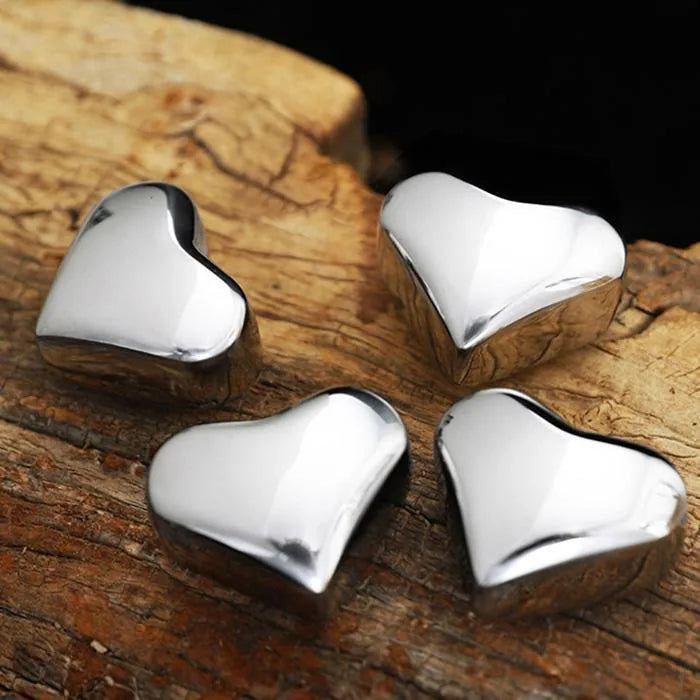 Gros plan sur quatre glaçons réutilisables en forme de cœur posés sur une bûche de bois brut.