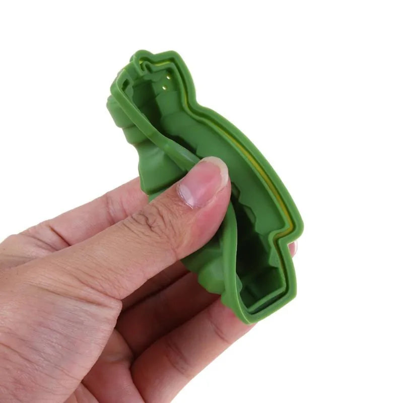 Gros plan sur une main tenant le moule à glaçons Grenade en silicone souple pour montrer sa flexibilité