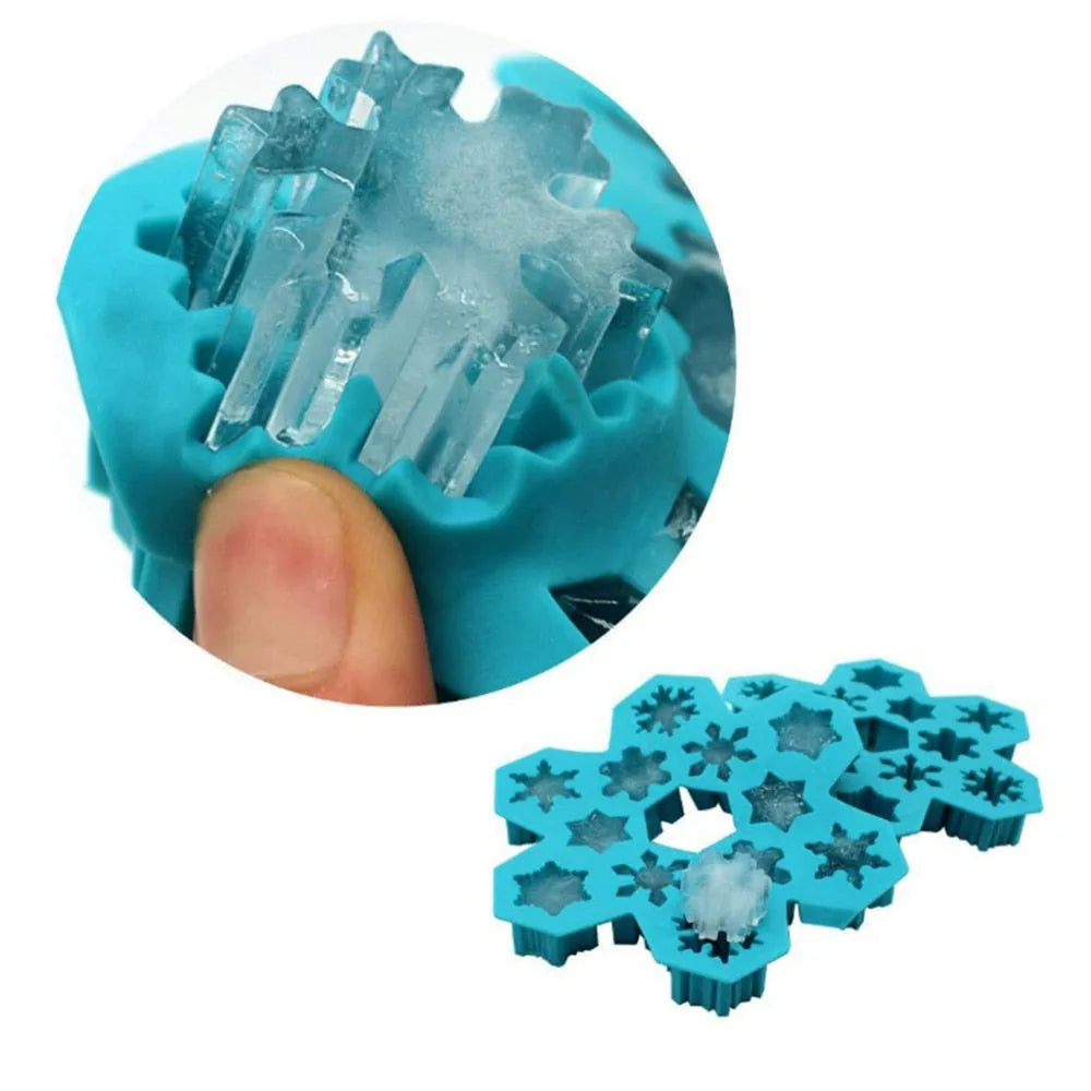 Gros plan sur un doigt démoulant des glaçons en forme de flocon de neige depuis le moule en silicone turquoise.