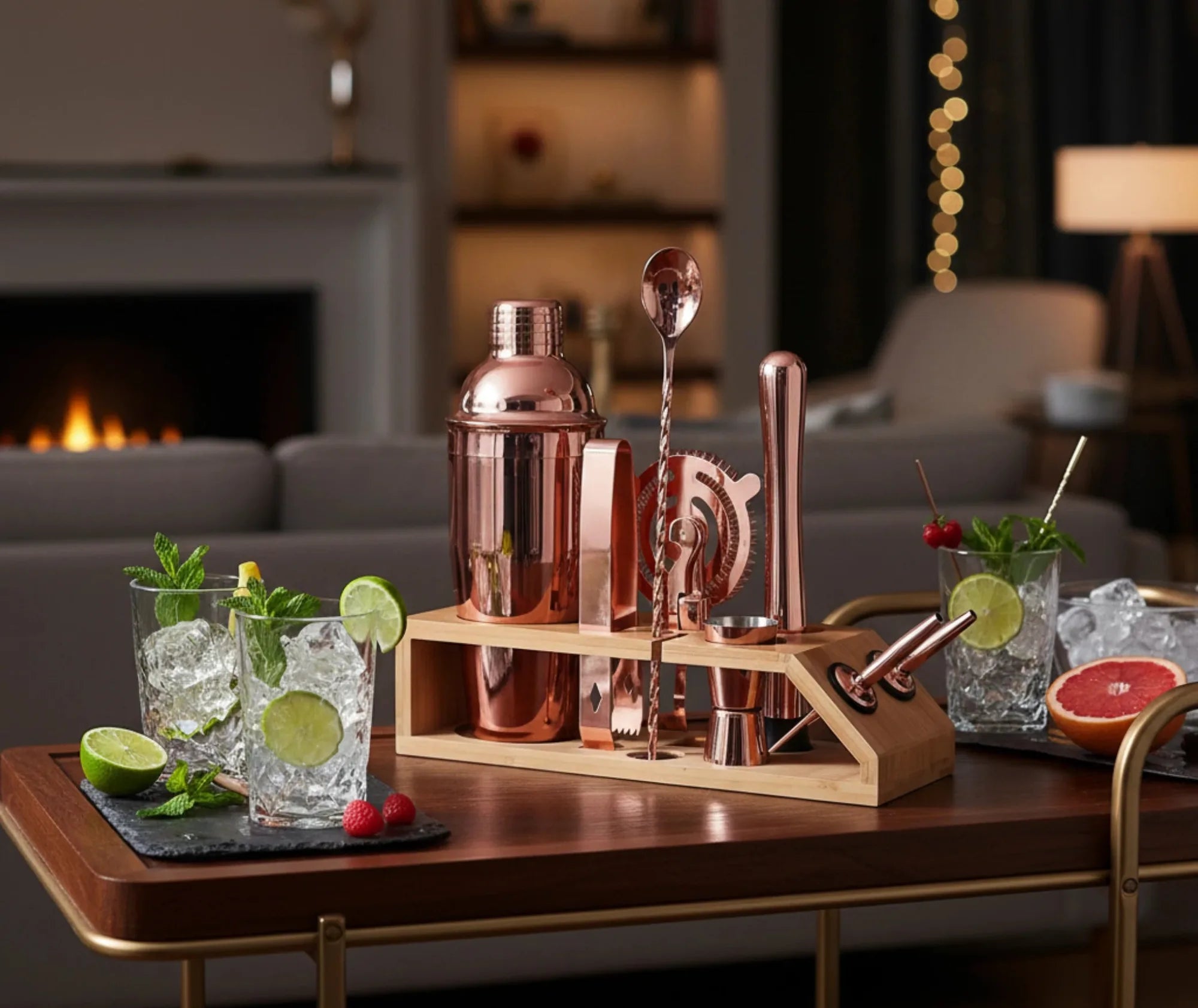 Kit cocktail rose gold posé sur une desserte, mojitos servis devant une cheminée