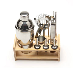 Kit cocktail en bois complet avec shaker et accessoires posés sur son support en bois, vue de face sur fond blanc.
