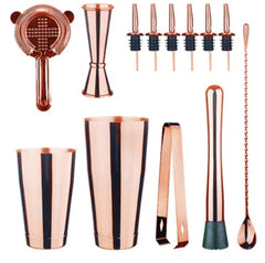 Les accessoires du kit cocktail Boston professionnel en finition rose gold disposés à plat sur fond blanc.