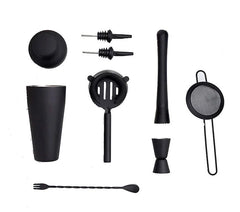 Vue détaillée de tous les accessoires du kit cocktail débutant disposés séparément : shaker, passoires, doseur, pilon, cuillère et becs verseurs