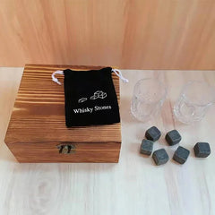 Coffret en bois fermé du kit de verres à whisky, accompagné de la pochette Whisky Stones, des 2 verres en cristal et des 6 pierres disposées à côté