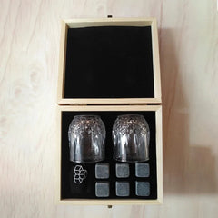Vue de dessus du coffret en bois ouvert du kit de verres à whisky, avec les 2 verres en cristal et les 6 pierres alignées