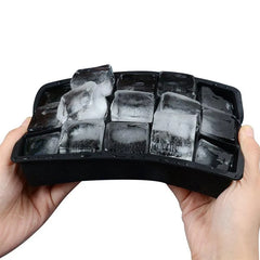 Mains tenant le moule à glaçons en silicone souple rempli de glaçons, démonstration de la flexibilité du matériau