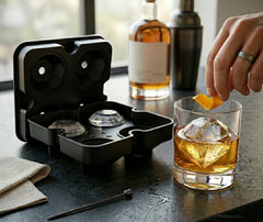 Moule à glaçons diamant sur un bar, avec une bouteille de whisky et un verre garni d'un glaçon diamant et d'un zeste d'orange
