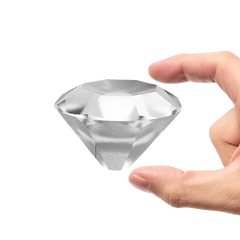 Gros plan sur un glaçon en forme de diamant tenu entre deux doigts