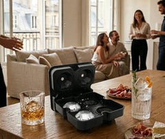 Moule à glaçons diamant posé sur une table basse lors d'une soirée entre amis, avec des verres de whisky et de cocktail