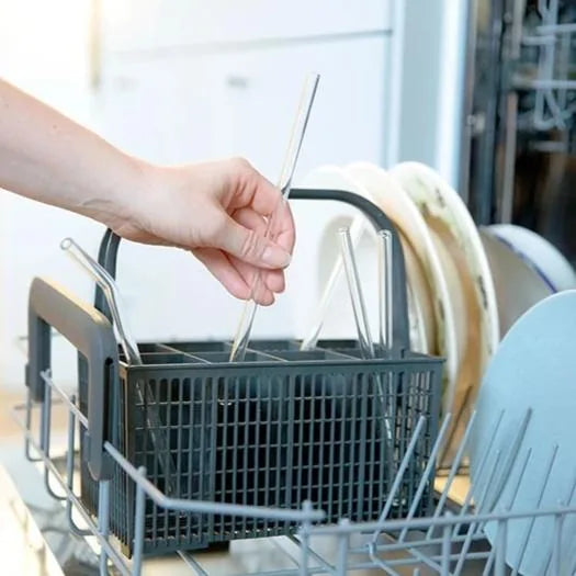 Une main place une paille en verre dans le panier à couverts d'un lave-vaisselle pour illustrer son entretien facile.