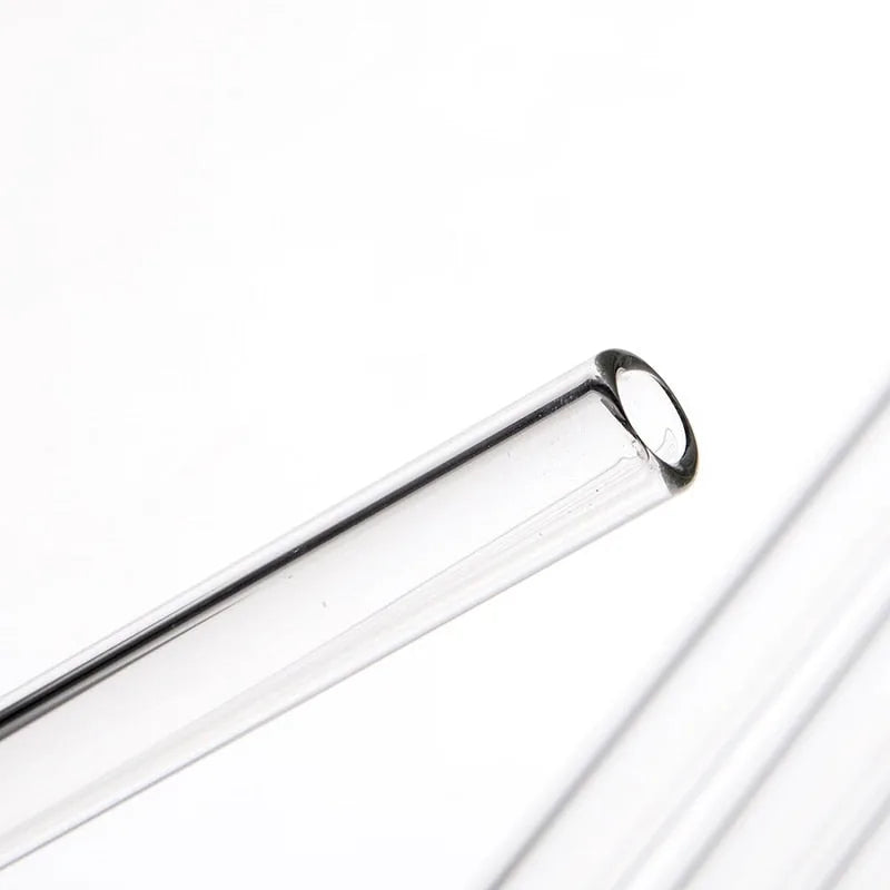 Gros plan macro sur l'embout arrondi d'une paille en verre transparent, mettant en valeur la finition polie.