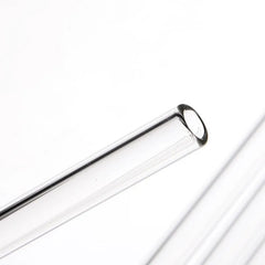 Gros plan macro sur l'embout arrondi d'une paille en verre transparent, mettant en valeur la finition polie.