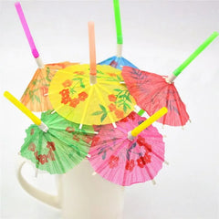 Pailles cocktail à parasol multicolores ouvertes et plantées dans une tasse blanche, packshot sur fond blanc