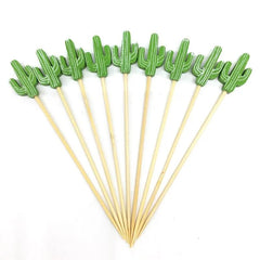 Dix piques à cocktail en forme de cactus disposés en éventail sur fond blanc.