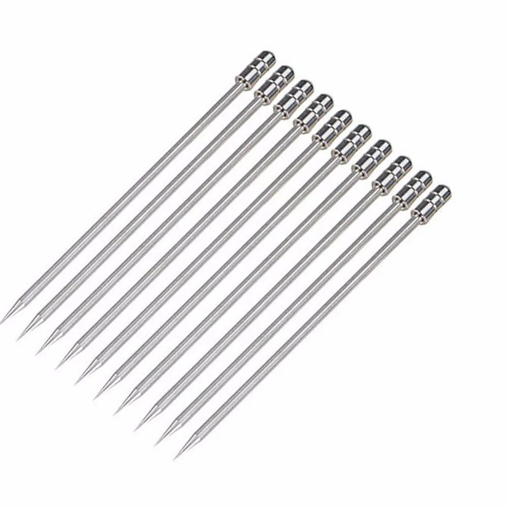 Lot de dix piques à cocktail en inox alignés en éventail sur fond blanc.