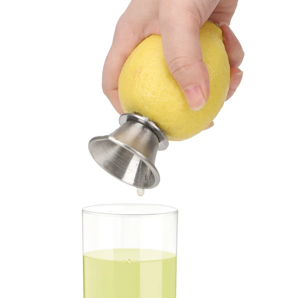 Le presse-agrume à main pressé sur un citron, le jus coulant directement dans un verre sur fond blanc