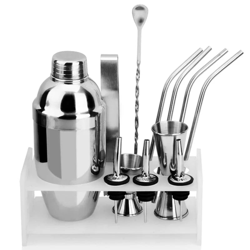 Coffret Set à Cocktail complet avec shaker, doseurs, pailles en inox et cuillère à mélange présenté sur son support en bois blanc, fond blanc