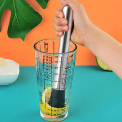 Une main utilise la tige de broyage du set barman cocktail pour piler un citron dans le verre mesureur, recette tequila
