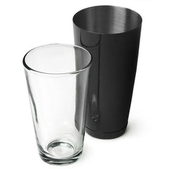 Les deux pièces du shaker cocktail Boston séparées : le gobelet en acier inoxydable noir mat et le verre en cristal côte à côte.