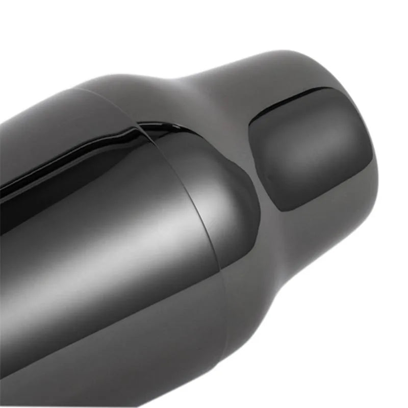 Gros plan sur la jointure et le bouchon du shaker cocktail design noir, finition brillante effet miroir.