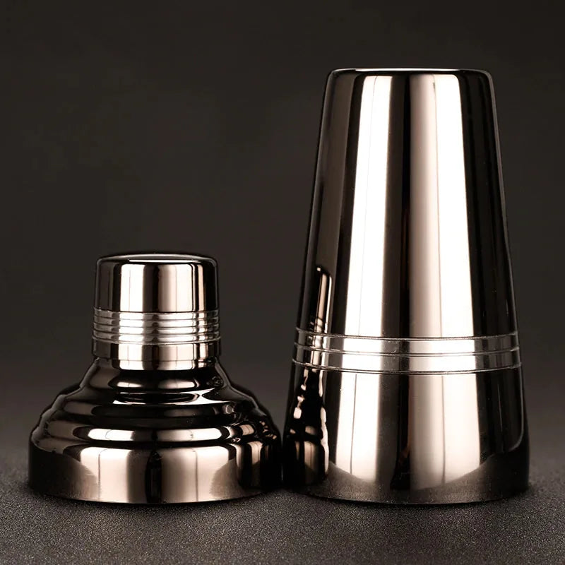 Vue éclatée du shaker cocktail noir montrant le corps et le bouchon filtrant séparés.