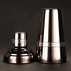 Vue éclatée du shaker cocktail noir montrant le corps et le bouchon filtrant séparés.