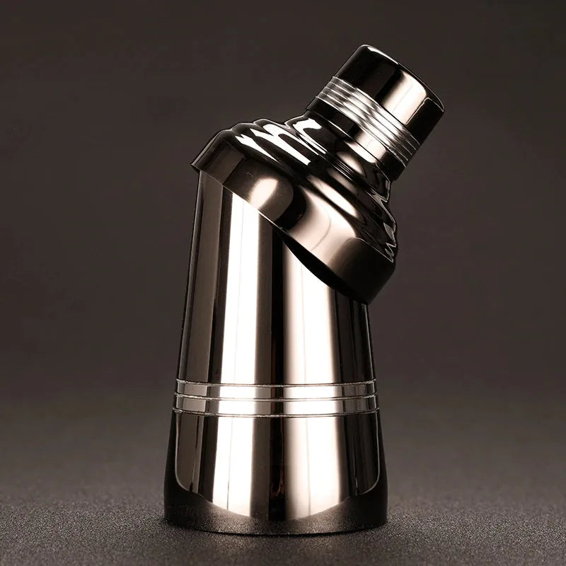 Shaker cocktail noir photographié en angle incliné avec le bouchon partiellement dévissé, reflets métalliques mis en valeur.