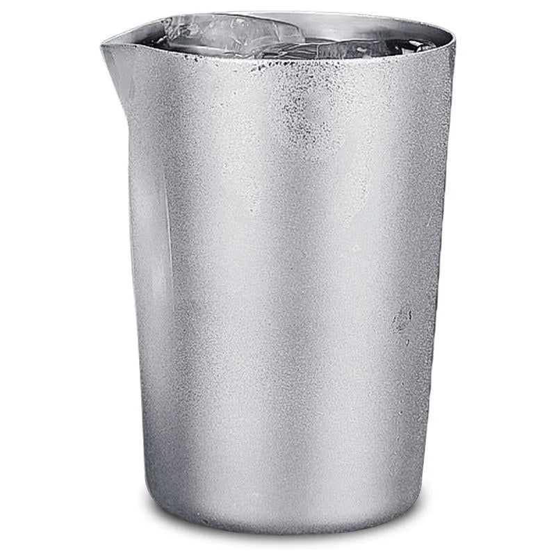Verre à mélange cocktail en inox rempli de glaçons, photographié sur fond blanc