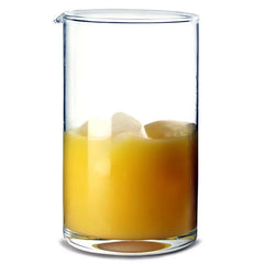 Verre à mélange rempli de glaçons et d'un cocktail orange vif, photographié en gros plan sur fond blanc.