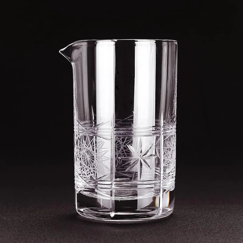 Gros plan sur le verre à mélange vintage vide, mettant en valeur les motifs de gravure étoilée taillés dans le cristal sur fond noir.