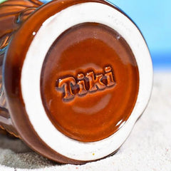 Gros plan sur le fond du verre à rhum Tiki, révélant l'inscription "Tiki" gravée dans la céramique