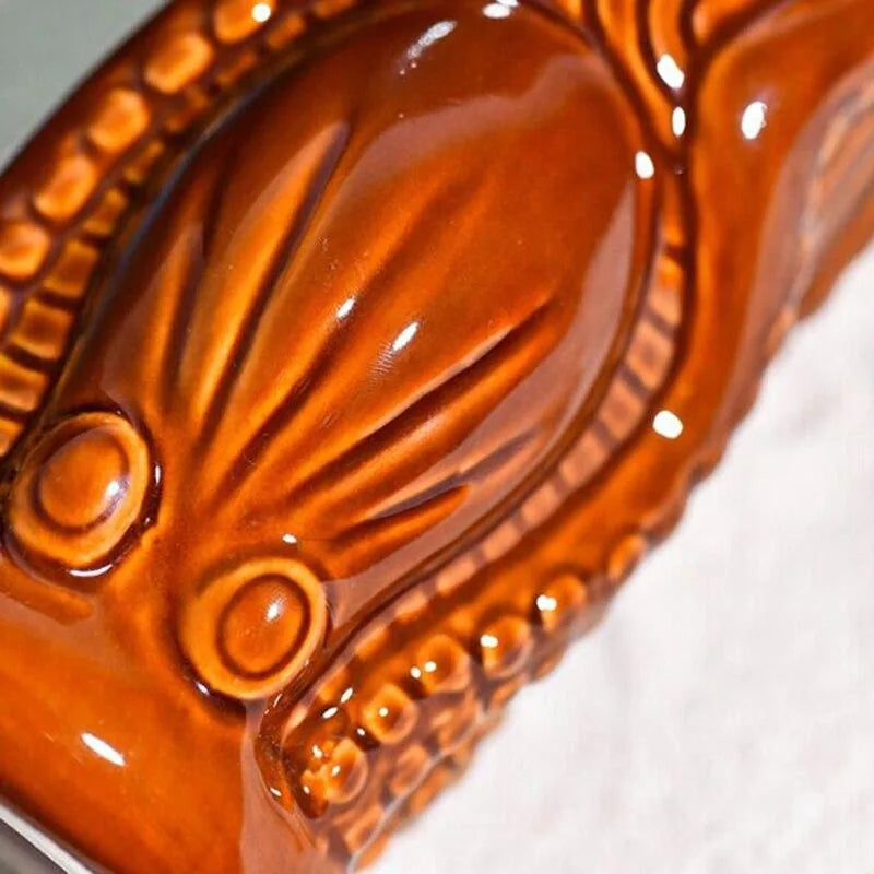 Gros plan sur le relief texturé et le vernis brillant de la céramique du verre à rhum Tiki