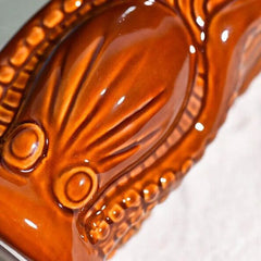 Gros plan sur le relief texturé et le vernis brillant de la céramique du verre à rhum Tiki