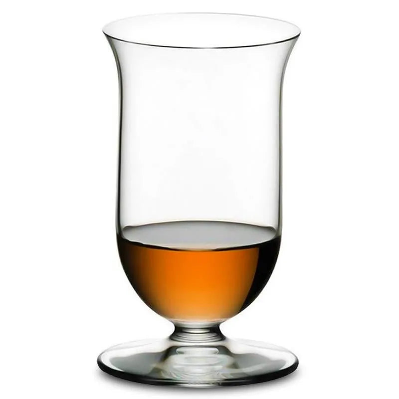 Verre à whisky à pied Riedel photographié en packshot sur fond blanc, rempli de whisky ambré.
