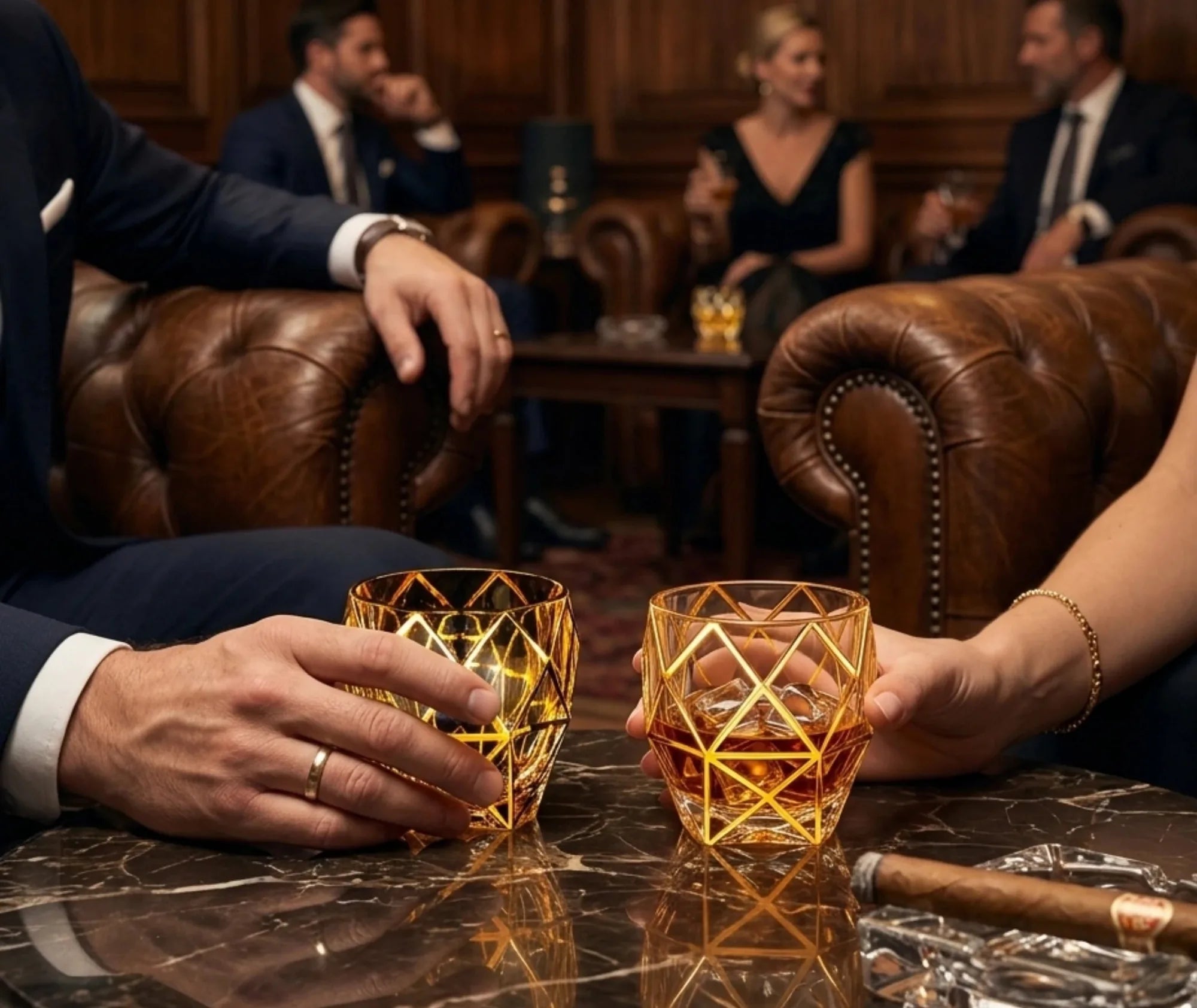 Deux verres à whisky de luxe tenus par des convives dans un salon en cuir avec un cigare posé sur la table