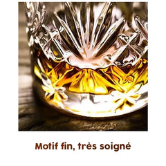 Gros plan sur le motif en étoile finement taillé au fond du verre à whisky rempli d'alcool ambré.