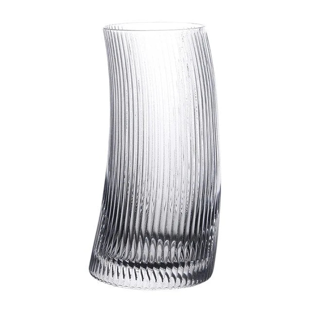 Verre à cocktail courbé transparent avec design strié, photographié seul sur fond blanc