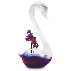 Verre à cocktail cygne au col transparent et à la base en verre irisé bleu-violet, décoré de fleurs séchées violettes, sur fond blanc