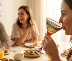 Femme dégustant un cocktail dans un verre martini à dorures lors d'un dîner entre amies